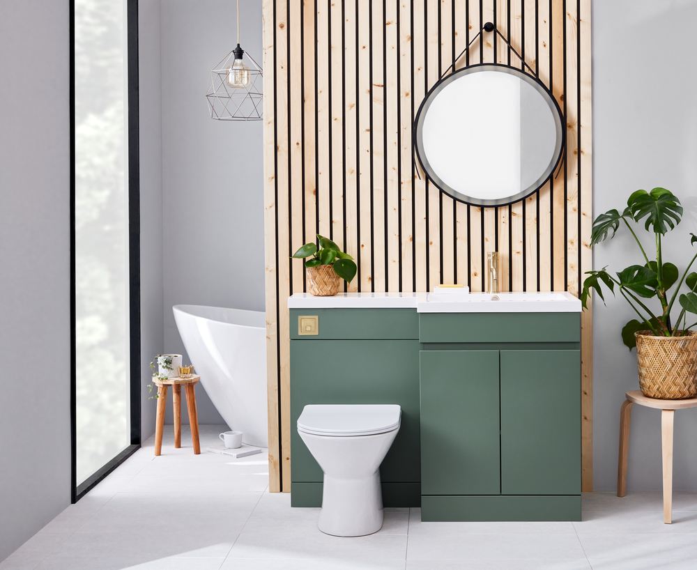 Sage green bathroom furniture with a round mirror and matching toilet unit